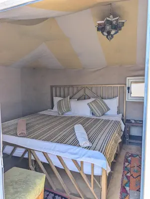 a bedroom with a bed in a tent at Luxury Desert Camp Merzouga with Air Conditioning and Heating in Merdani
