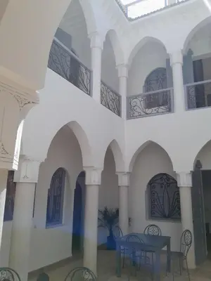 a room with arches and a table and chairs at Villa Agora, Villa à la campagne proche Marrakech in Marrakech