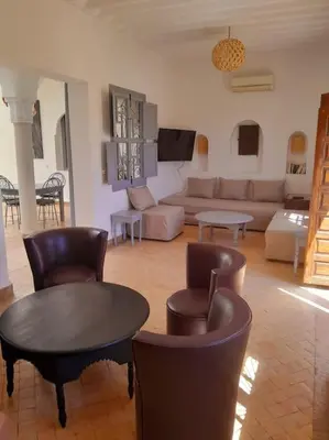 a living room with a couch and a table and chairs at Villa Agora, Villa à la campagne proche Marrakech in Marrakech