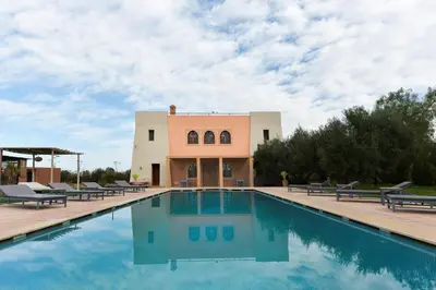 a swimming pool in front of a villa at Villa Agora, Villa à la campagne proche Marrakech in Marrakech