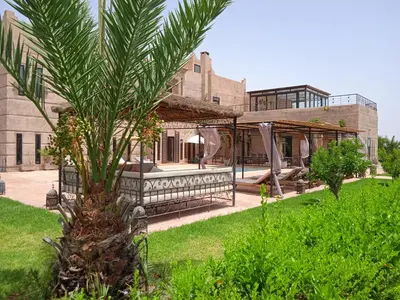 a palm tree in front of a house at Villa Malaa'ika in Marrakech