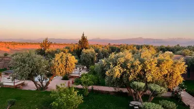 a park with trees and benches in a field at Villa Malaa'ika in Marrakech