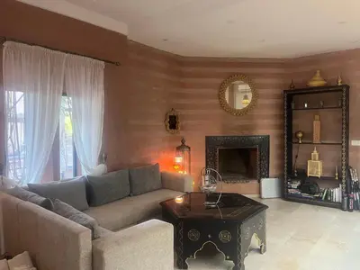 a living room with a couch and a table at Villa Malaa'ika in Marrakech