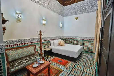 a room with a bed and a couch and a table at Riad Farouzi Fes in Fès