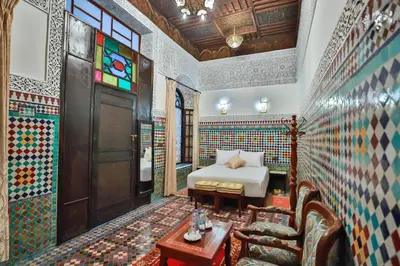 a bedroom with a bed and a table in a room at Riad Farouzi Fes in Fès