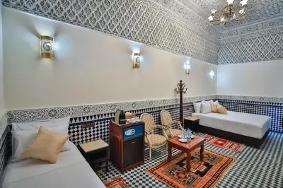 a living room with a bed and a table at Riad Farouzi Fes in Fès
