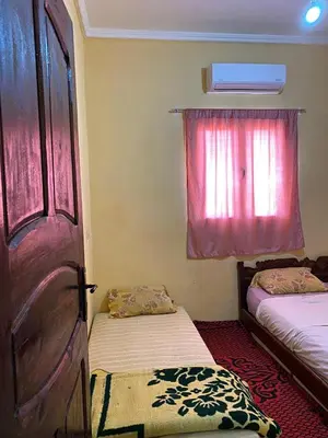 a room with two beds and a door and a window at Boka Dunes Houses Merzouga in Merzouga