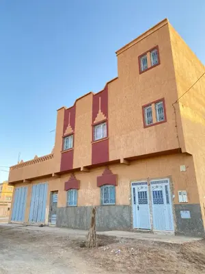 a building with blue doors on the side of it at Boka Dunes Houses Merzouga in Merzouga