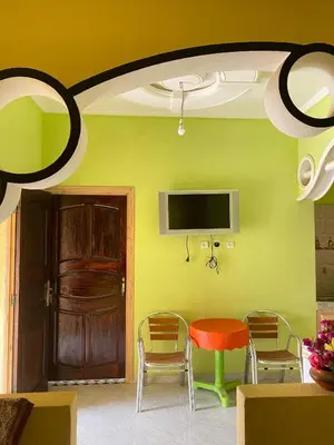 a room with a table and chairs and a tv at Boka Dunes Houses Merzouga in Merzouga