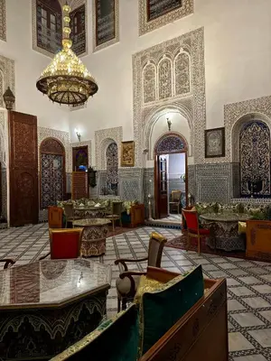a large room with a chandelier and tables and chairs at Riad Damia Suite & Spa in Fès