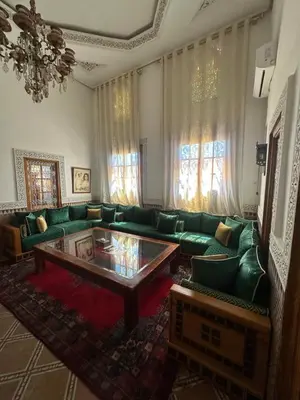a living room with a green couch and a coffee table at Riad Damia Suite & Spa in Fès