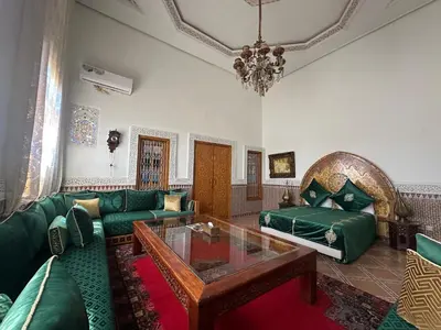 a living room with a green couch and a table at Riad Damia Suite & Spa in Fès
