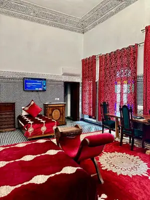a living room with a bed and a table at Riad Damia Suite & Spa in Fès