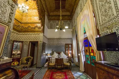 a room with a table and chairs in a building at Riad Damia Suite & Spa in Fès