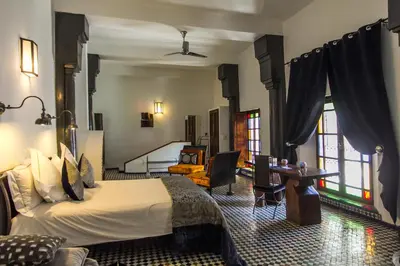 a hotel room with a bed and a living room at Riad Laaroussa in Fès