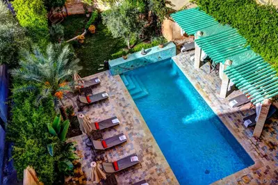 an overhead view of a swimming pool with chaise lounge chairs at Riad Laaroussa in Fès