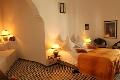a bedroom with a bed and two lamps in it at Riad Laaroussa in Fès