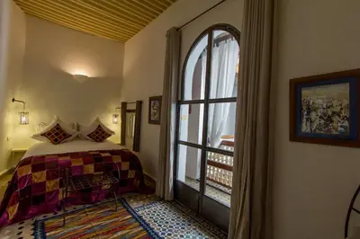 a bedroom with a bed and a large window at Riad Laaroussa in Fès