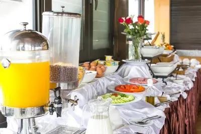 a buffet line with food and a pitcher of orange juice at Zahrat Al Jabal in Fès