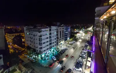 a city street at night with cars and buildings at Zahrat Al Jabal in Fès
