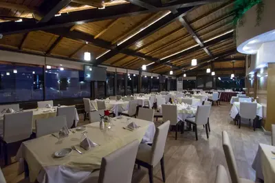 a dining room with white tables and chairs at Zahrat Al Jabal in Fès