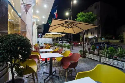 a group of tables and chairs with an umbrella at Zahrat Al Jabal in Fès