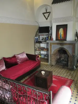 a living room with a couch and a fireplace at Riad Attarine in Fès