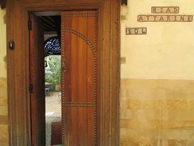 an entrance to a building with a wooden door at Riad Attarine in Fès