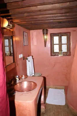 a bathroom with a copper sink and two windows at Riad Attarine in Fès