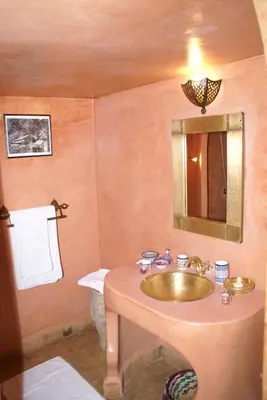 a bathroom with a gold sink and a mirror at Riad Attarine in Fès