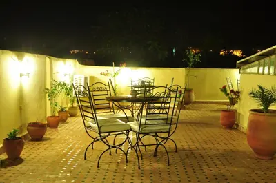 a table and chairs on a patio at night at Riad Sara in Fès