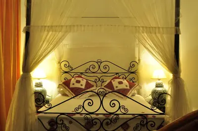 a bedroom with a bed with a canopy and pillows at Riad Sara in Fès