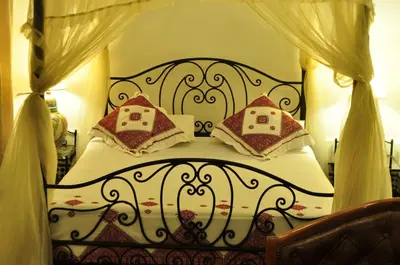 a bedroom with a black and white bed with pillows at Riad Sara in Fès