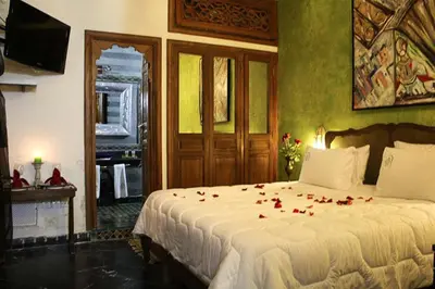 a bedroom with a bed with red roses on it at Riad Arabesque & Spa in Fès