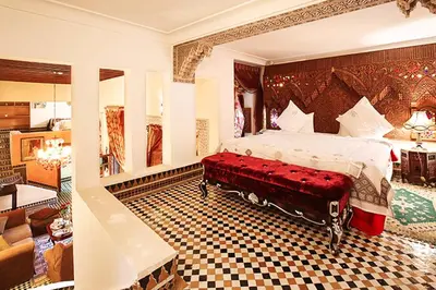 a bedroom with a large bed with a red bench at Riad Arabesque & Spa in Fès