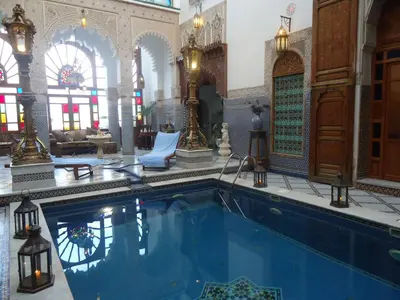 an indoor swimming pool in a building with a large room at Riad Arabesque & Spa in Fès
