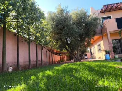 a hammock in a yard next to a fence at Villa khaddouj Marrakech in Marrakech