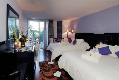 a bedroom with two beds and a desk with a computer at Royal Mirage Fes Hotel in Fès
