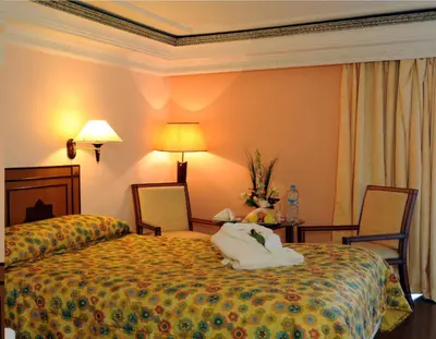 a hotel room with a bed and a table and chairs at Royal Mirage Fes Hotel in Fès