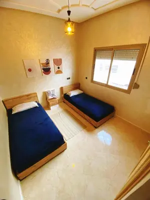 a bedroom with two beds and a window at Appartement calme à Fès in Fès