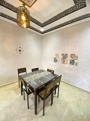 a dining room with a table and chairs and a ceiling at Appartement calme à Fès in Fès