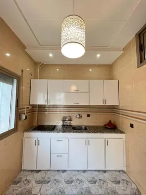 a kitchen with white cabinets and a sink at Appartement calme à Fès in Fès