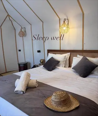 a bed with a hat on top of it at Luxury Camp Merzouga & Activities in Merzouga