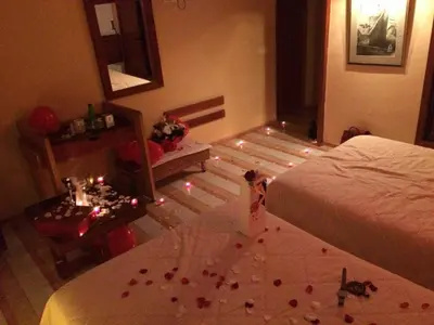 a bedroom with a bed and a table with roses on the floor at Sidi Harazem in Fès