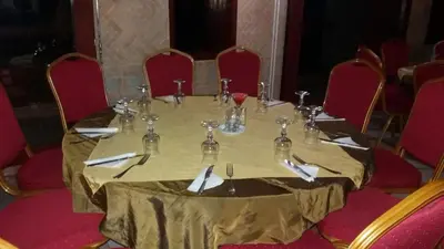 a table in a room with red chairs around it at Sidi Harazem in Fès