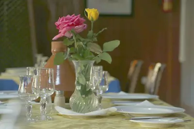 a vase of flowers on a table with glasses at Sidi Harazem in Fès