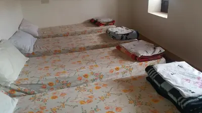 three twin beds in a room with at Gîte Assafar in Kalaat MGouna