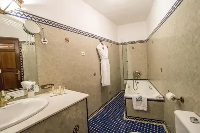 a bathroom with a bath tub and a sink at Riad Myra in Fès