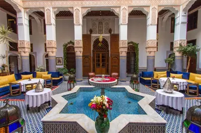 a lobby with a pool in the middle of a building at Riad Myra in Fès