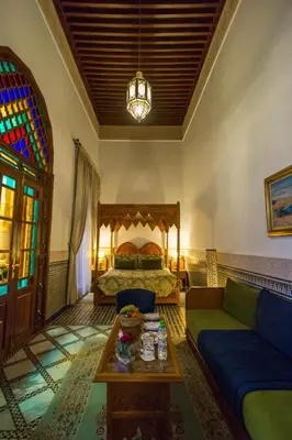 a living room with a bed and a couch and a table at Riad Myra in Fès